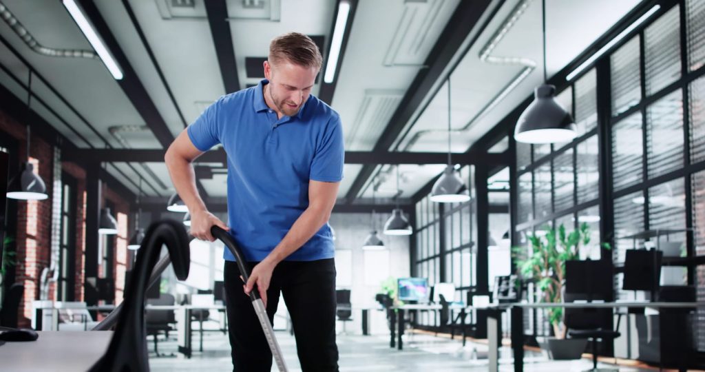 98532908-the-office-cleaner-keeping-desks-tidy